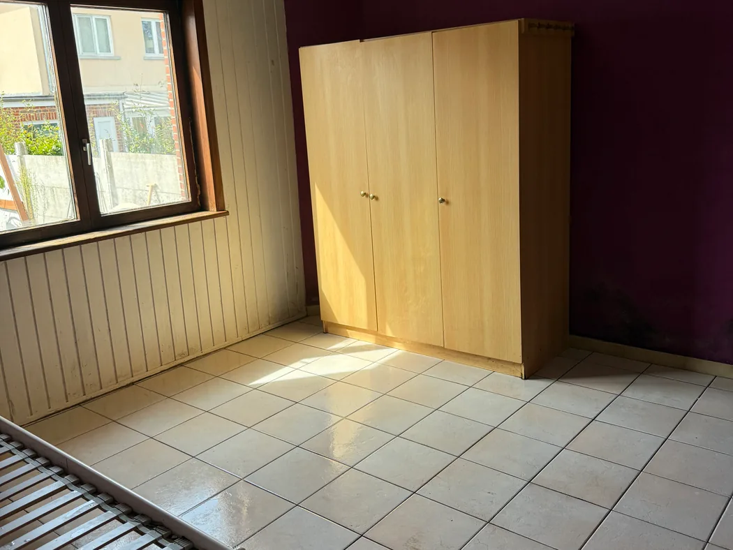 La même chambre après intervention, vidée et nettoyée, sol carrelé dégagé