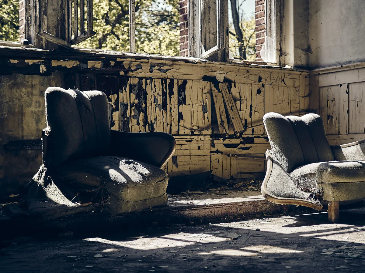 Pièce dégradée après une occupation, mobilier abandonné et peinture écaillée